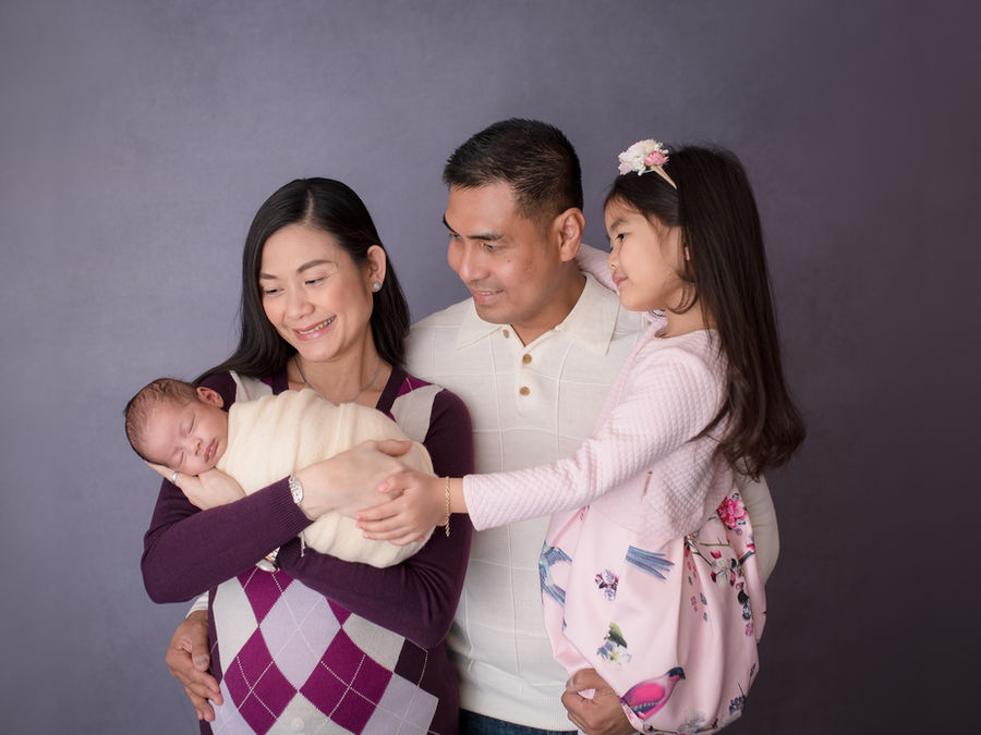 Family welcoming a newborn in the studio